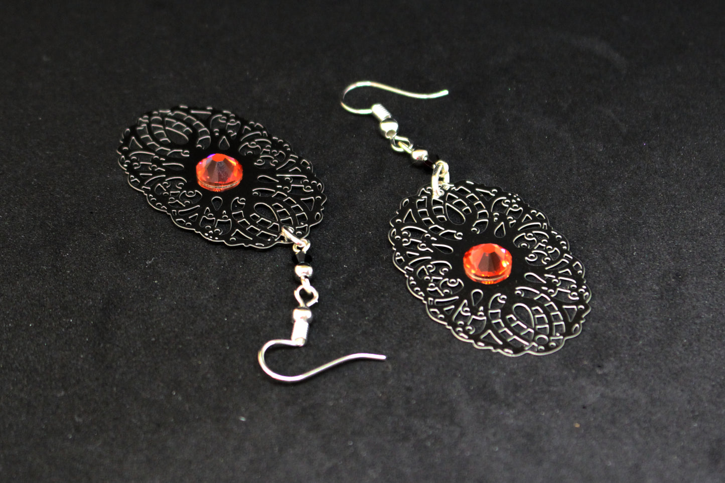 Boucles d'oreilles ajouré noires avec cristaux oranges