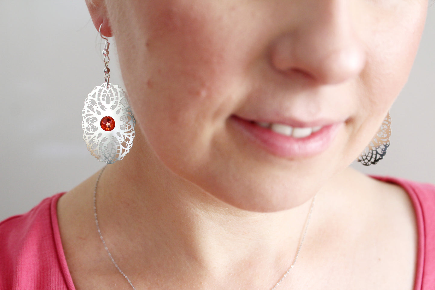 Boucles d'oreilles ajouré argentées avec cristaux oranges